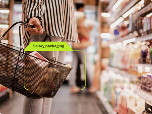 low angle shot of a woman holding a shopping basket in front of supermarketing aisle