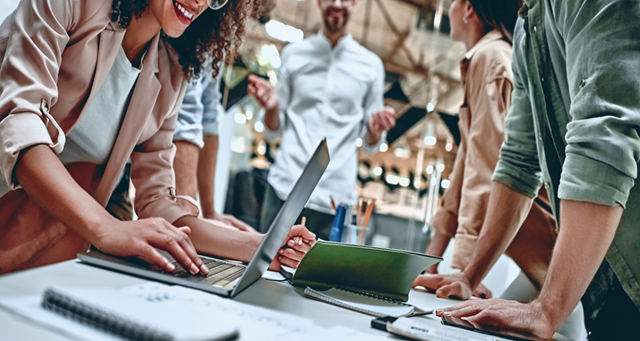 Close up shot of an office meeting with a woman using a laptop