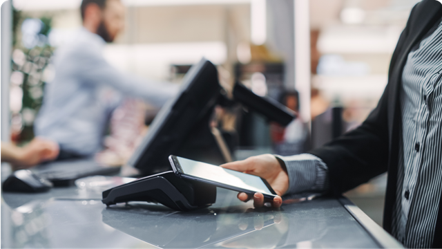 A woman using her mobile phone to pay 