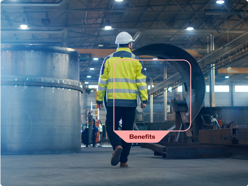 A factory worker walking towards large machinery