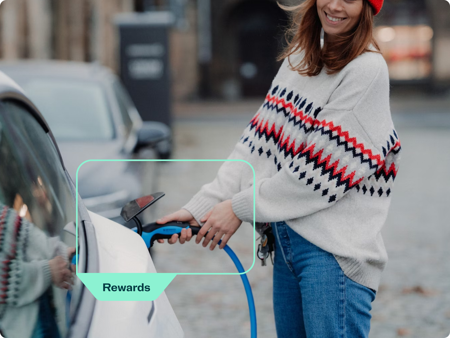 Woman holding a charge plug charging an EV