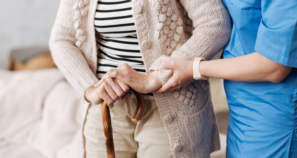 a carer helping an elderly woman