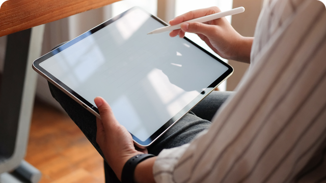 a woman using a stylus on a tablet