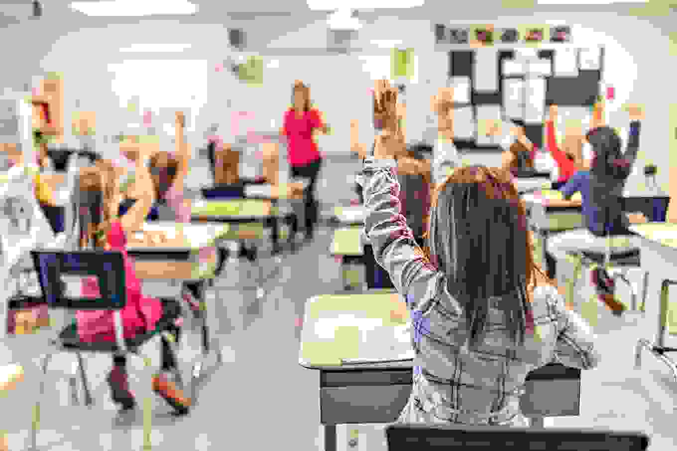 Closeup classroom student riasing hand