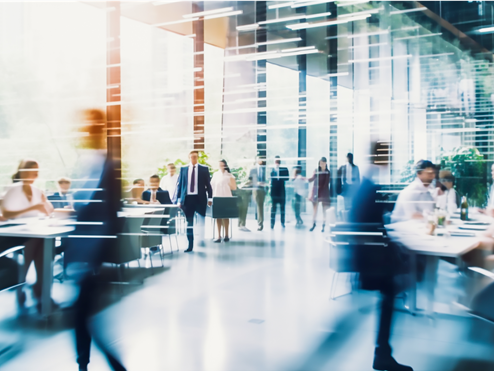 Artistic blurry image of a large office foyer with people moving around