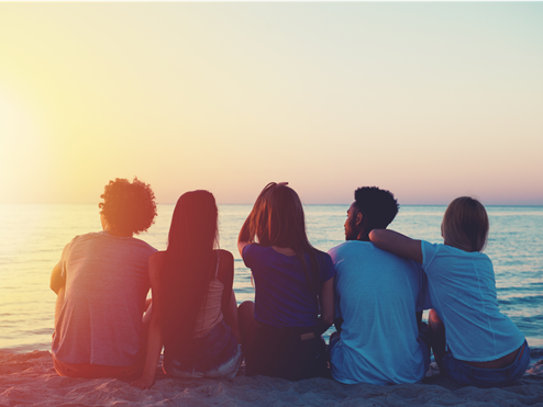 friends-sitting-on-beach-sunset