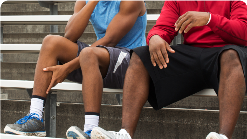 two people in sports clothing sitting in a grandstand