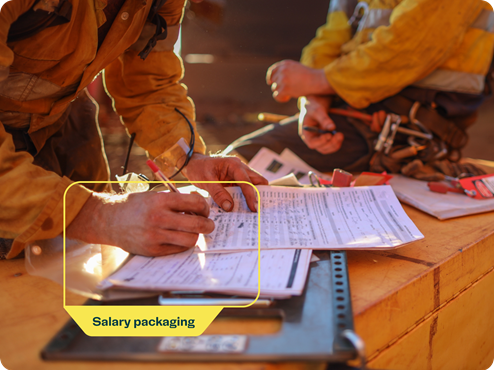 Workers at a construction site reviewing documents with a 'Salary packaging' label highlighted on the image.